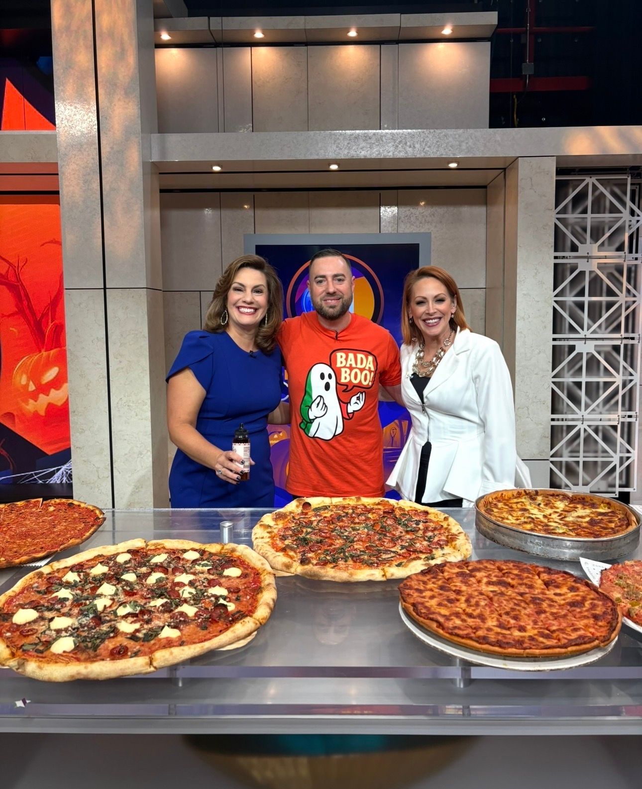 Jonathan Porter on a Chicago news set with local anchors and a spread of Chicago pizzas